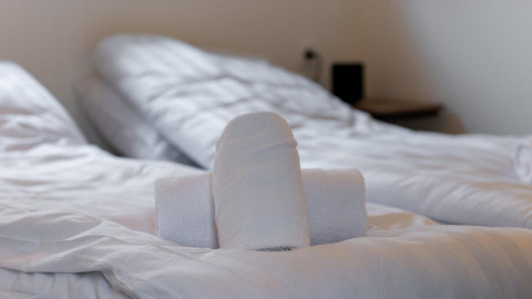 Toallas enrolladas sobre una cama en Cube La Mer en Kohnenhof, Luxemburgo, ambiente acogedor de hotel.