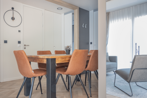 Salle à manger moderne avec table en bois, six chaises en cuir et déco épurée à Domus, Kohnenhof, Luxembourg.