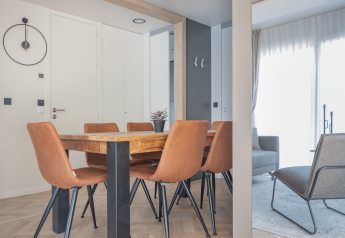 Moderne eetkamer met houten tafel, zes leren stoelen en licht interieur bij Domus, Kohnenhof, Luxemburg.