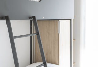 Modernes Etagenbett mit grauen und Holzelementen im Domus bei Kohnenhof in Luxemburg mit Tageslicht.