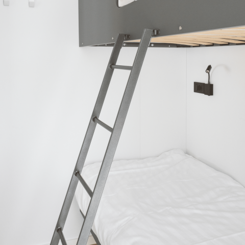 Modernes Schlafzimmer im Domus bei Kohnenhof, Luxemburg, mit Etagenbett, Leiter und weißer Bettwäsche.