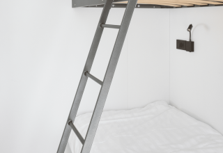 Modernes Schlafzimmer im Domus bei Kohnenhof, Luxemburg, mit Etagenbett, Leiter und weißer Bettwäsche.