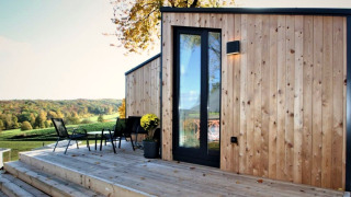 Buitenterras aan Panorama Cottage met houten gevelbekleding en prachtig zicht op het glooiende landschap.