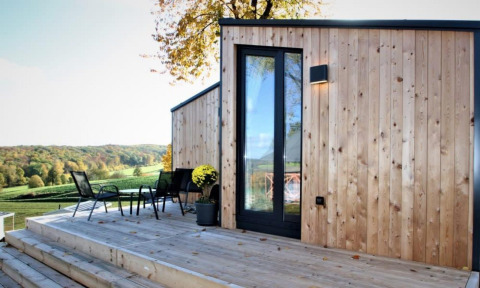 Buitenterras aan Panorama Cottage met houten gevelbekleding en prachtig zicht op het glooiende landschap.