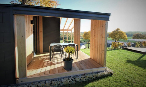Terraza moderna con mesa y sillas vista a campos en Panorama Cottage, Gulperberg, Países Bajos.