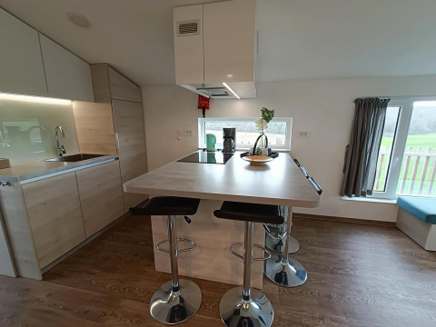 Moderne keuken met eiland in Panorama Cottage, Gulperberg, Nederland, lichte materialen en raam uitzicht.