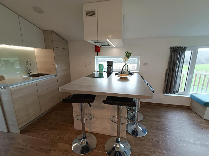 Cocina moderna con isla en Panorama Cottage, Gulperberg, Países Bajos, muebles claros y amplia ventana.