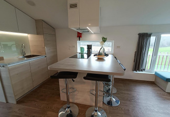 Modern kitchen and dining island at Panorama Cottage, Gulperberg, Netherlands, with light wood furnishings.