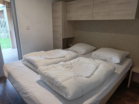 Tweepersoonsbed met twee dekbedden in Panorama Cottage Gulperberg, Nederland, modern en licht interieur.