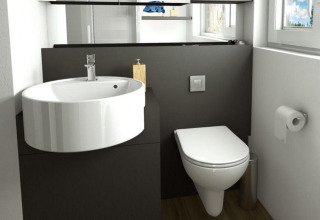 Baño moderno en Panorama Cottage, Gulperberg, Países Bajos, con lavabo, inodoro y ventana grande.