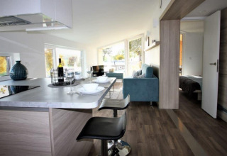 Interior moderno de Panorama Cottage en Gulperberg, Países Bajos, con cocina, sala y dormitorio al fondo.