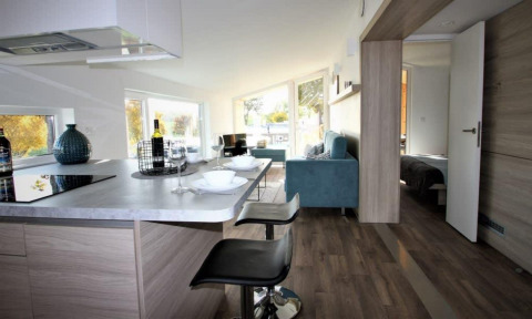 Modern interieur van Panorama Cottage op Gulperberg, Nederland, met keuken, zithoek en slaapkamer.