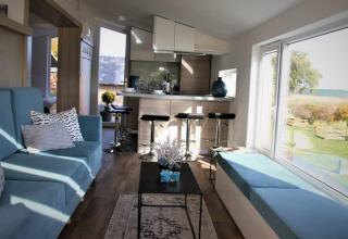 Indretning af Panorama Cottage på Gulperberg i Nederlandene med store vinduer og moderne møbler.