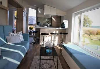 Interior of Panorama Cottage at Gulperberg, Netherlands, with modern decor and large scenic windows.