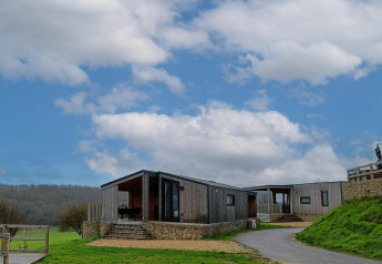 Panorama Cottage at Gulperberg, Netherlands, a modern wooden lodge with scenic countryside and blue sky.