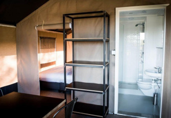 Interior view of Panorama Lodge at Gulperberg in the Netherlands, showing bedroom, bathroom and shelves.