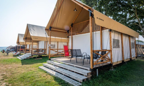 Row of modern mountain lodges with decks at Lodge de Montagne, Gulperberg, Netherlands, on a sunny day.