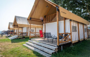 Række af moderne bjerglodges med terrasser i Lodge de Montagne ved Gulperberg, Holland, på en solrig dag.
