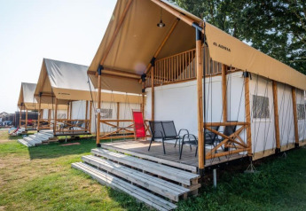 Rij moderne berghutten met terrassen aan Lodge de Montagne bij Gulperberg, Nederland, op een zonnige dag.