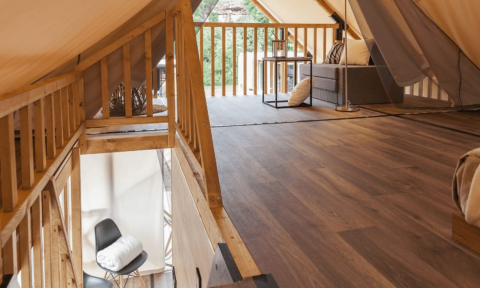 Interiør af Lodge de Montagne i Gulperberg, Holland, set fra en hems med udsigt til stue og balkon.