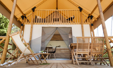 Wooden deck with chairs and glamping tent at Lodge de Montagne on Gulperberg, Netherlands, outdoor view.