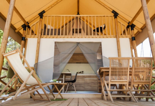 Wooden deck with chairs and glamping tent at Lodge de Montagne on Gulperberg, Netherlands, outdoor view.