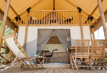 Houten terras en zitgedeelte bij Lodge de Montagne op Gulperberg, Nederland, glamping tent buitenaanzicht.