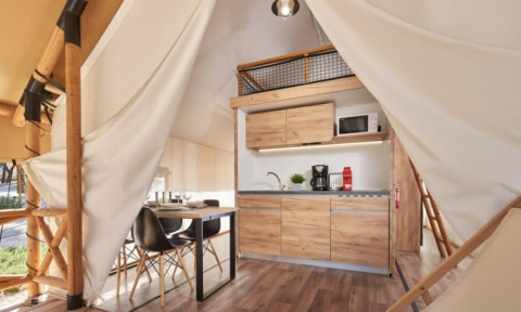 Innenansicht eines Lodge de Montagne Petite Safari-Zelts mit moderner Küche und Essbereich.