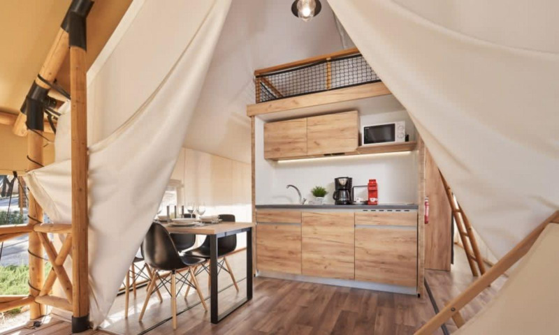 Interior de una tienda safari Lodge de Montagne Petite con cocina moderna y zona de comedor.