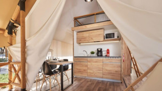 Intérieur d'une tente safari Lodge de Montagne Petite avec cuisine moderne et coin repas élégant.