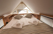 Letto accogliente nella tenda safari Lodge de Montagne Petite a Gulperberg, Paesi Bassi, con asciugamani arrotolati.