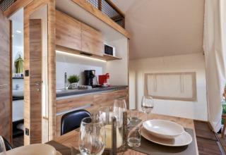 Interiør af Lodge de Montagne Petite safari-telt ved Gulperberg i Holland, moderne køkken og spisebord.