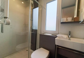 Moderne badkamer in het Grandeur Chalet te Gulperberg, Nederland, met douche, toilet en lavabo.
