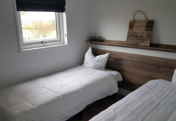 Modernes Zweibettzimmer im Grandeur Panorama am Gulperberg, Niederlande, mit zwei Betten und Fenster.