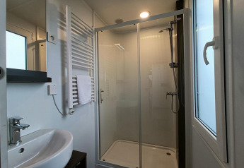 Moderne badkamer in Grandeur Panorama op Gulperberg, Nederland, met douche, wastafel en handdoek.
