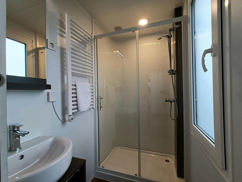 Baño moderno en Grandeur Panorama, Gulperberg, Países Bajos, con ducha, lavabo y ventana grande.