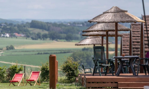 Vista relajante desde Woodlodge en Gulperberg, Países Bajos con sombrillas de paja y sillas plegables.