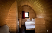 Træindretning af en lille hytte med dobbeltseng på Woodlodge i Gulperberg, Holland.