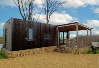 Lodge Bellevue moderno al Gulperberg nei Paesi Bassi con rivestimento in legno, base in pietra e veranda.