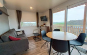 Moderne lodge Bellevue ved Gulperberg, Holland, med sofa, spisebord og udsigt over landskabet.