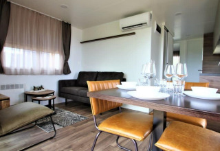 Moderne leef- en eetruimte in lodge Bellevue op Gulperberg, Nederland, met stijlvol meubilair en tafelservies.