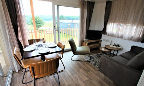 Moderne leefruimte in lodge Bellevue op de Gulperberg, Nederland met eetplek en uitzicht op het groen.