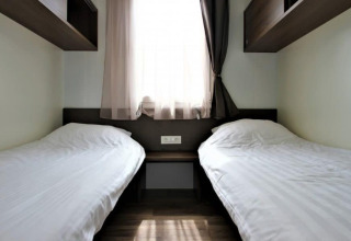 Deux lits simples avec draps blancs dans une chambre de la Bellevue à Gulperberg, Pays-Bas.