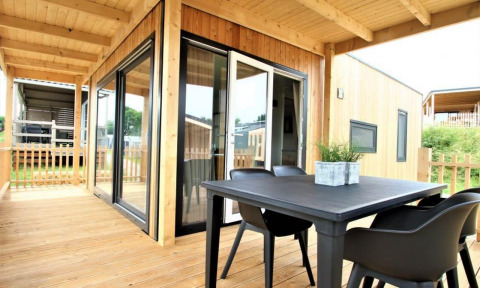 Terraza de madera con mesa y sillas en la cabaña Bellevue en Gulperberg, Países Bajos, ambiente moderno.