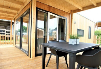 Houten terras met tafel en stoelen bij lodge Bellevue op Gulperberg in Nederland, moderne uitstraling.