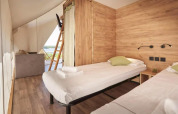 Indvendig udsigt af Lodge de Montagne Medium safari telt på Gulperberg, Nederlandene, med to enkeltsenge.