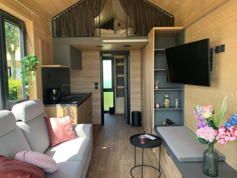 Interno di una moderna Tiny House al Gulperberg, Paesi Bassi, con zona giorno, cucina e soppalco.