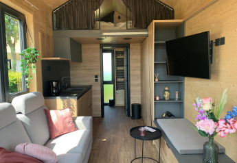 Indretning af en moderne Tiny House-lodge i Gulperberg, Holland, med stue, køkken og hems.