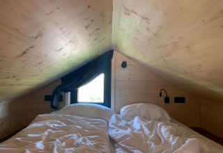 Gemütliches Schlafzimmer unterm Dach im Tiny House bei Gulperberg Lodge, Niederlande.