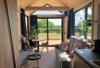 Gemütliche Tiny House Lodge am Gulperberg in den Niederlanden mit Panoramafenstern und hellem Holz.